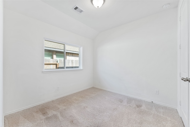 unfurnished room with light colored carpet and vaulted ceiling