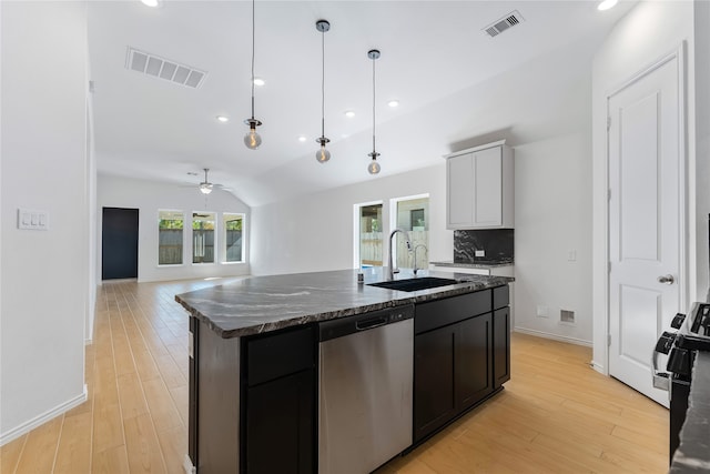 kitchen featuring ceiling fan, sink, stainless steel appliances, vaulted ceiling, and a kitchen island with sink