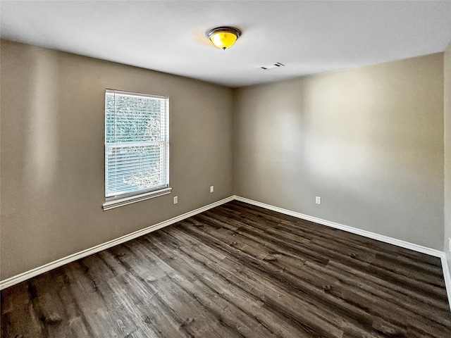 empty room with dark hardwood / wood-style flooring