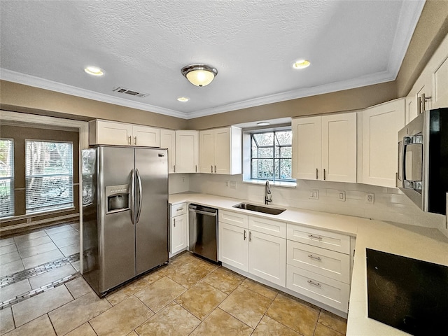 1519 Hannington Dr, Katy, TX 77450 - kitchen with stainless steel appliances, a sink, white cabinets, light countertops, and crown molding