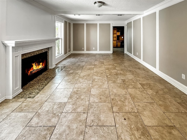 unfurnished living room featuring crown molding, a high end fireplace, and a textured ceiling