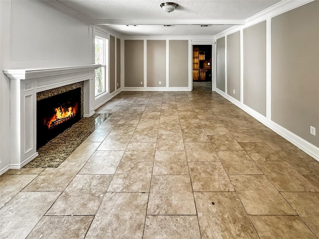 1519 Hannington Dr, Katy, TX 77450 - unfurnished living room with a textured ceiling, a high end fireplace, crown molding, and a decorative wall