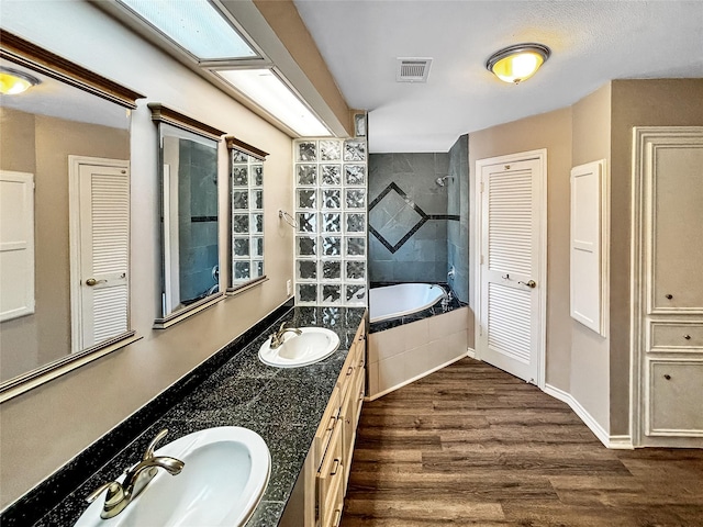 1519 Hannington Dr, Katy, TX 77450 - bathroom featuring a closet, tiled bath, double vanity, and wood finished floors