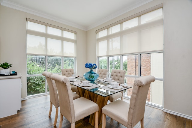 dining space with hardwood / wood-style floors and ornamental molding