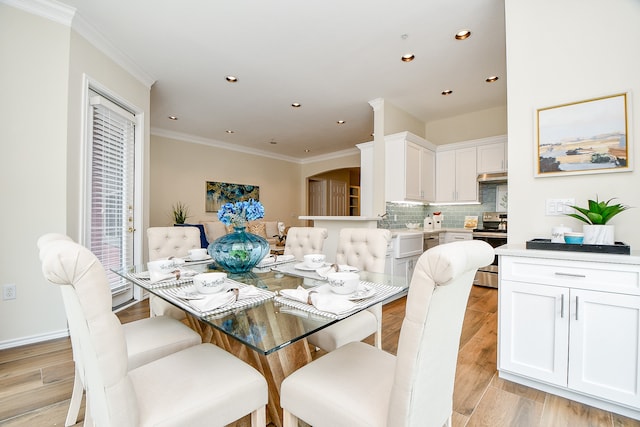 dining space with light hardwood / wood-style floors and crown molding