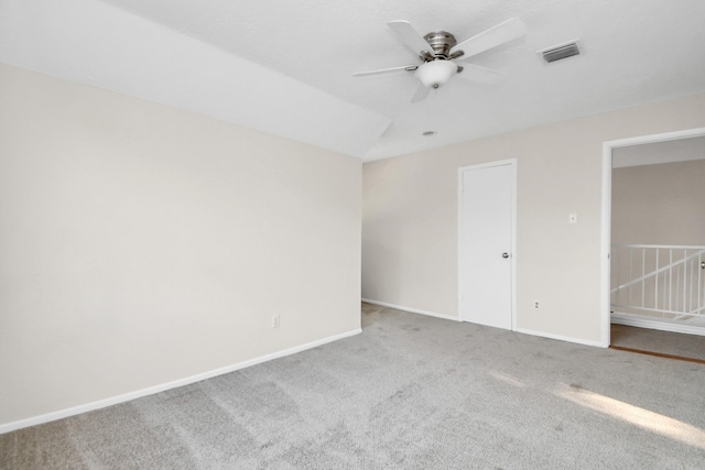 carpeted empty room featuring ceiling fan and vaulted ceiling