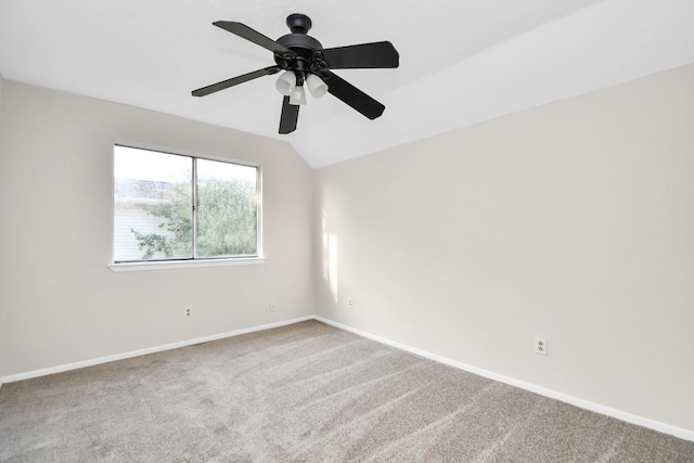 carpeted spare room featuring vaulted ceiling and ceiling fan