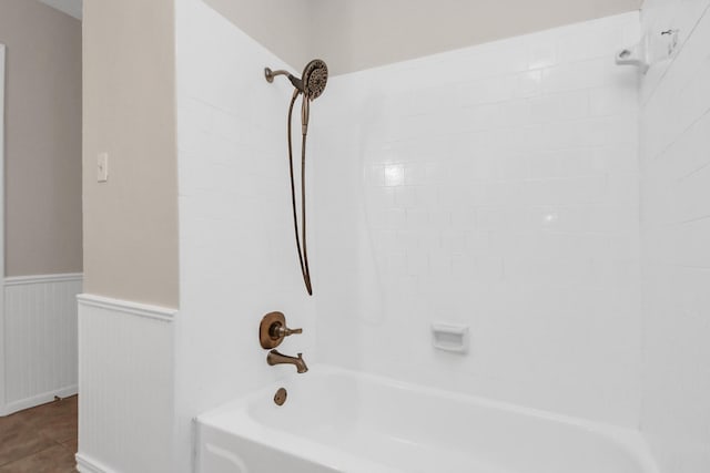 bathroom featuring tile patterned flooring and tiled shower / bath