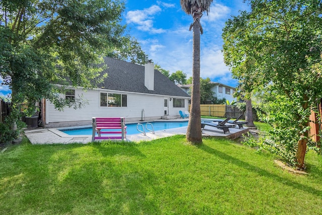 back of house with a patio, a fenced in pool, cooling unit, and a lawn