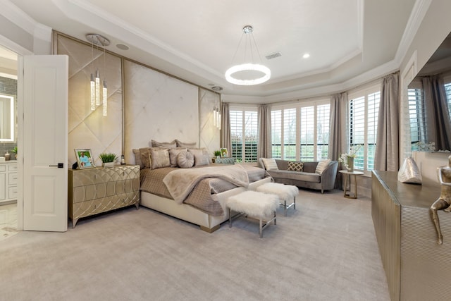 carpeted bedroom with ornamental molding and a tray ceiling