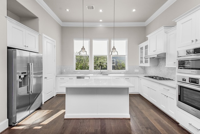 kitchen with a center island, dark hardwood / wood-style floors, decorative light fixtures, white cabinetry, and stainless steel appliances