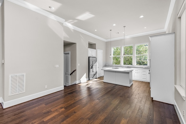 kitchen with white cabinetry, a center island, dark hardwood / wood-style floors, stainless steel fridge, and pendant lighting