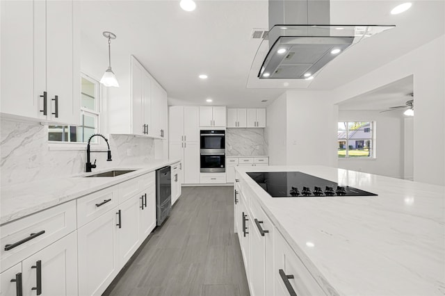 kitchen with decorative backsplash, light stone countertops, sink, black appliances, and white cabinets