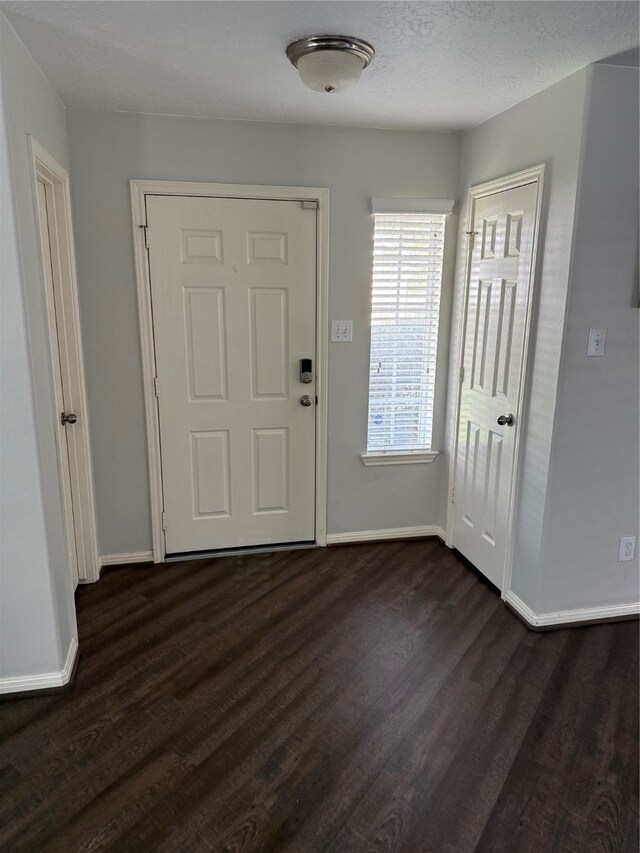 foyer entrance with a textured ceiling and dark hardwood / wood-style floors