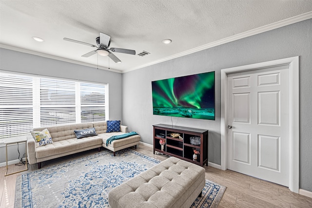 living room with a textured ceiling, light hardwood / wood-style floors, ceiling fan, and ornamental molding