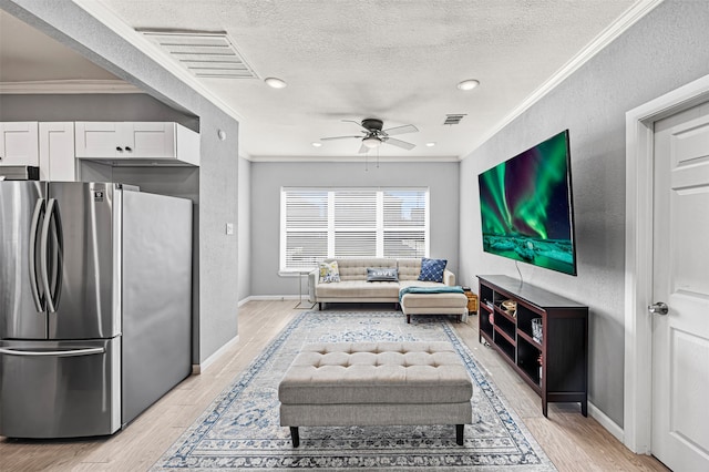 interior space with a textured ceiling, light wood-type flooring, ceiling fan, and ornamental molding