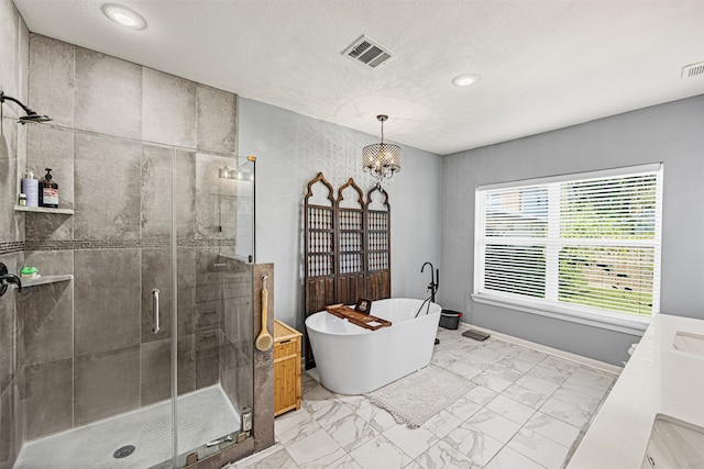 bathroom featuring separate shower and tub, vanity, a chandelier, and a textured ceiling