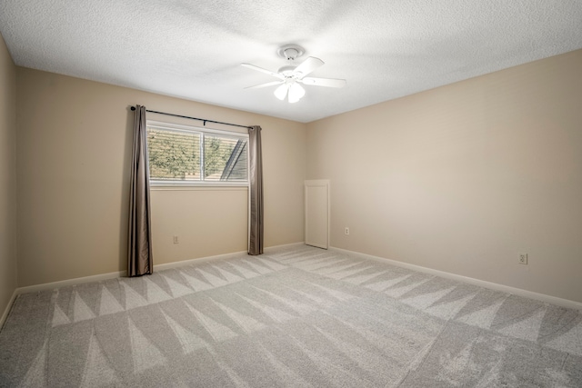 empty room with light carpet, a textured ceiling, and ceiling fan