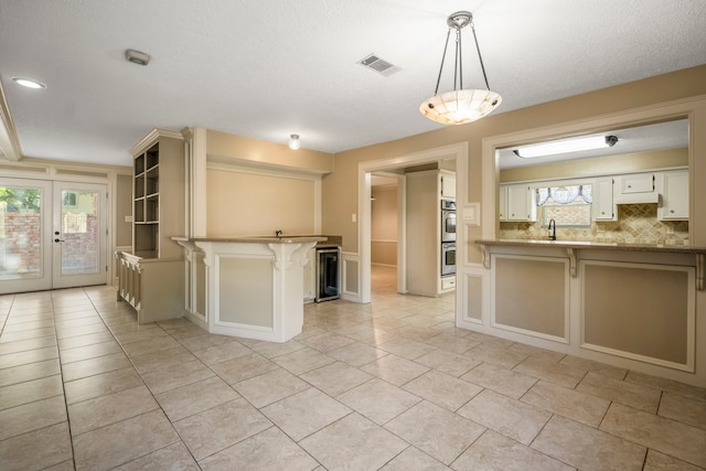 kitchen with white cabinetry, a wealth of natural light, hanging light fixtures, and a kitchen breakfast bar