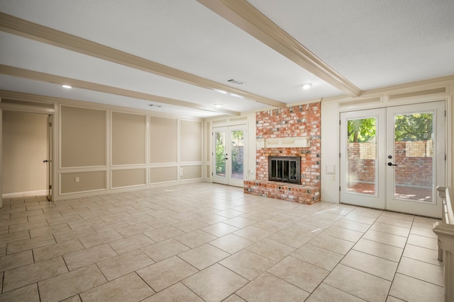 unfurnished living room featuring french doors, a brick fireplace, light tile patterned floors, a textured ceiling, and beamed ceiling