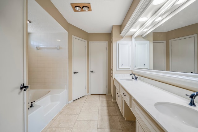 bathroom with a bathing tub, tile patterned flooring, and vanity