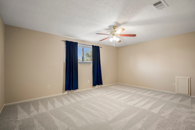 unfurnished room featuring a textured ceiling, ceiling fan, and light carpet