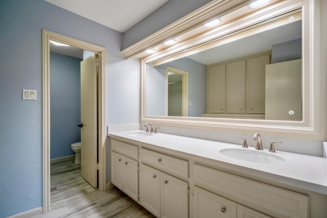 bathroom with hardwood / wood-style floors, vanity, and toilet