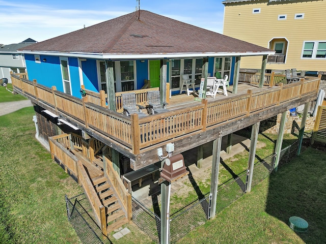 rear view of house featuring a deck and a lawn