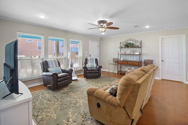 living room featuring crown molding, hardwood / wood-style floors, and ceiling fan