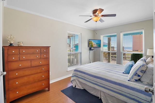 bedroom featuring ceiling fan, crown molding, and light hardwood / wood-style floors