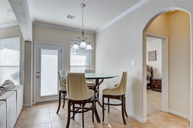 dining area with light tile patterned floors and crown molding