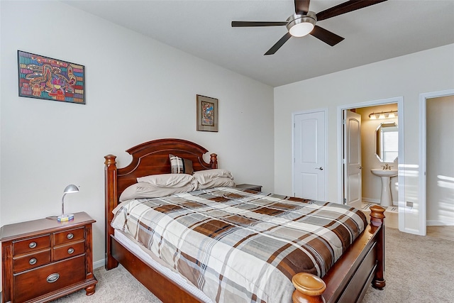 carpeted bedroom with ensuite bath, ceiling fan, and sink