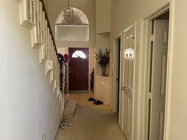 carpeted foyer featuring a high ceiling