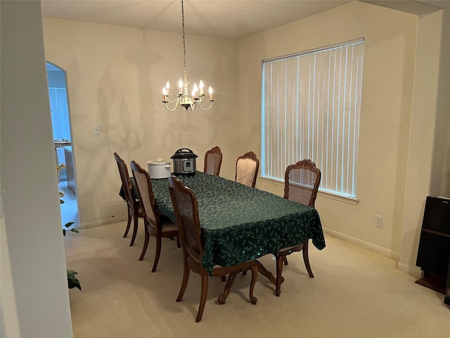 carpeted dining room featuring a notable chandelier