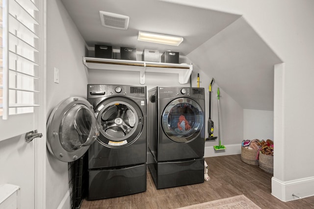 washroom featuring hardwood / wood-style flooring and washing machine and dryer