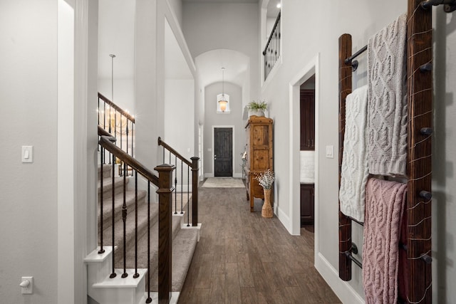 hall with dark wood-type flooring and a high ceiling