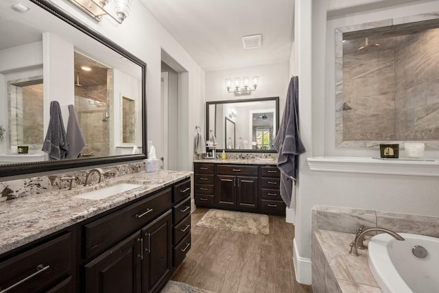 bathroom featuring independent shower and bath, vanity, and hardwood / wood-style floors