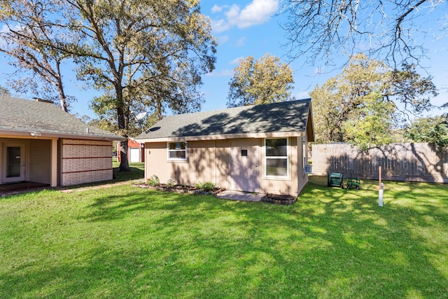 rear view of house featuring an outbuilding and a lawn