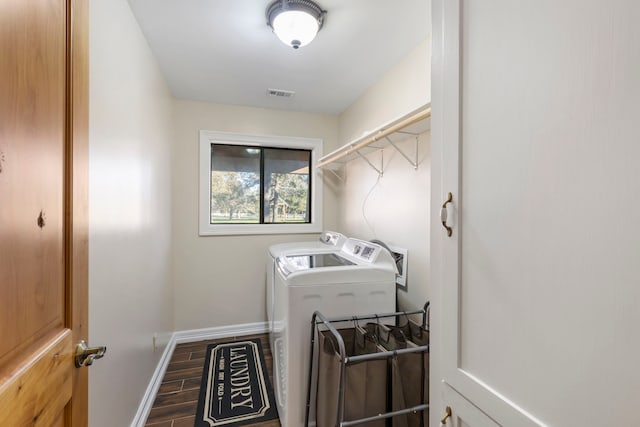 laundry area with dark hardwood / wood-style floors and washer and clothes dryer