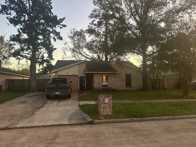 single story home with a garage and a yard