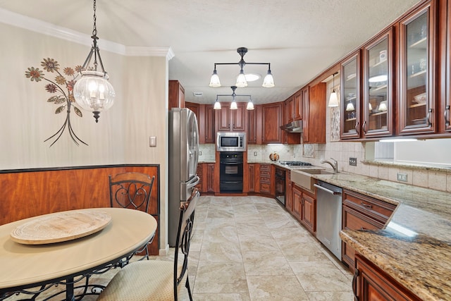 kitchen with hanging light fixtures, light stone counters, decorative backsplash, appliances with stainless steel finishes, and ornamental molding