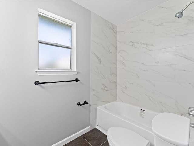 bathroom featuring tile patterned flooring, tiled shower / bath combo, and toilet