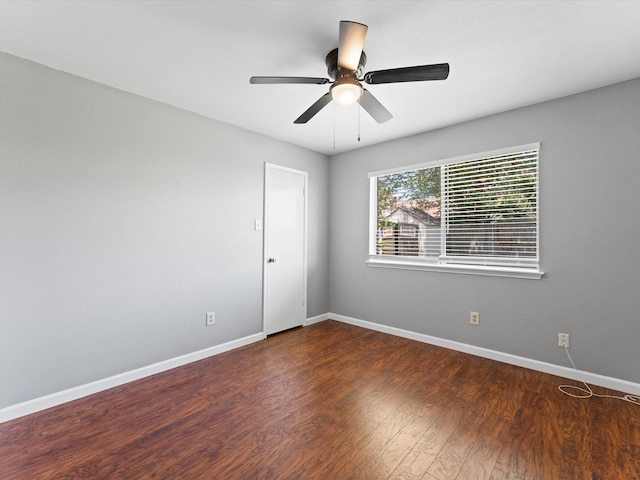 spare room with dark hardwood / wood-style flooring and ceiling fan