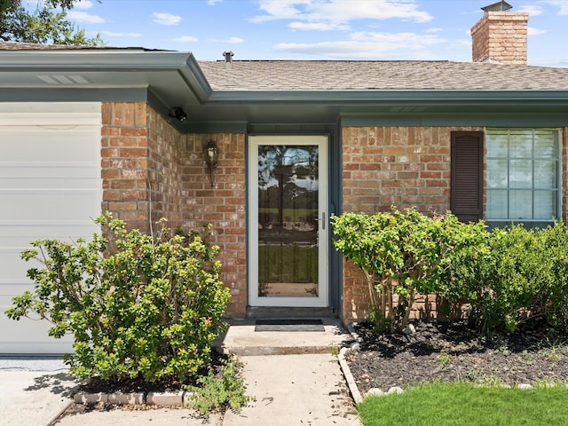 doorway to property with a garage