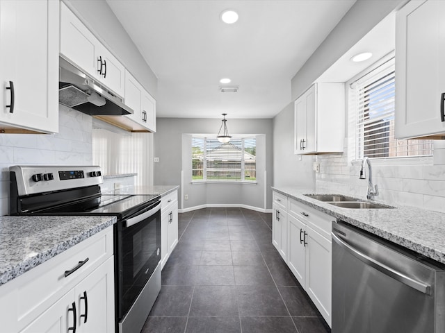 kitchen with sink, hanging light fixtures, light stone counters, white cabinets, and appliances with stainless steel finishes