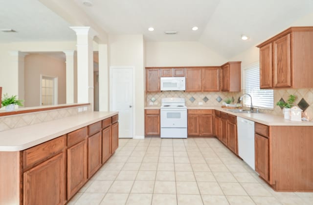 kitchen with sink, backsplash, decorative columns, vaulted ceiling, and white appliances