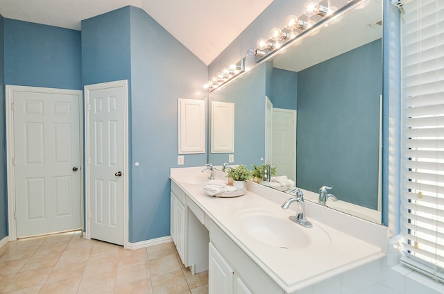 bathroom with tile patterned flooring, vanity, and vaulted ceiling