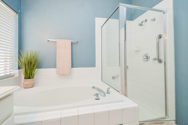 bathroom featuring vanity and independent shower and bath