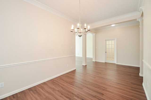 unfurnished room with a notable chandelier, dark hardwood / wood-style floors, ornamental molding, and ornate columns