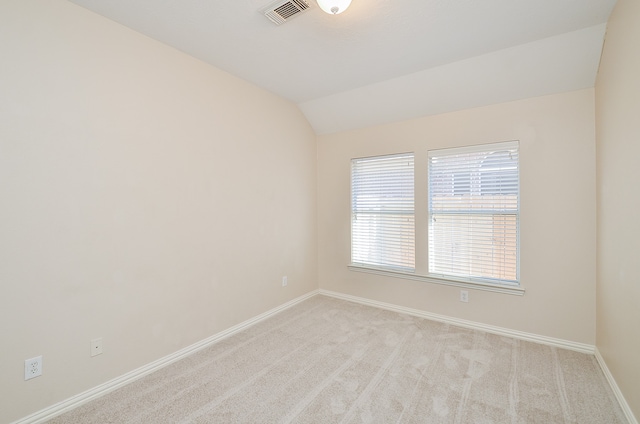 empty room with light colored carpet and lofted ceiling